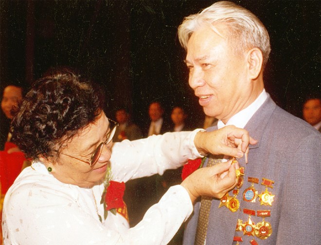 Phó Chủ tịch Nước Nguyễn Thị Bình gắn huy hiệu Anh hùng Lao động cho ông Đặng Văn Thân