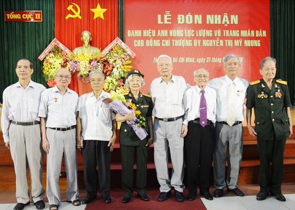 Thượng úy, CCB Nguyễn Thị Mỹ Nhung cùng đồng đội, người thân trong buổi lễ đón nhận danh hiệu Anh hùng LLVT nhân dân.